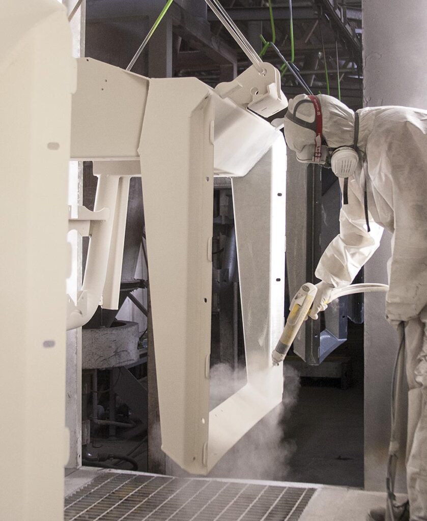 Lucrător Eurospand vopsește o componentă de mașină spandiconcime profesionale.